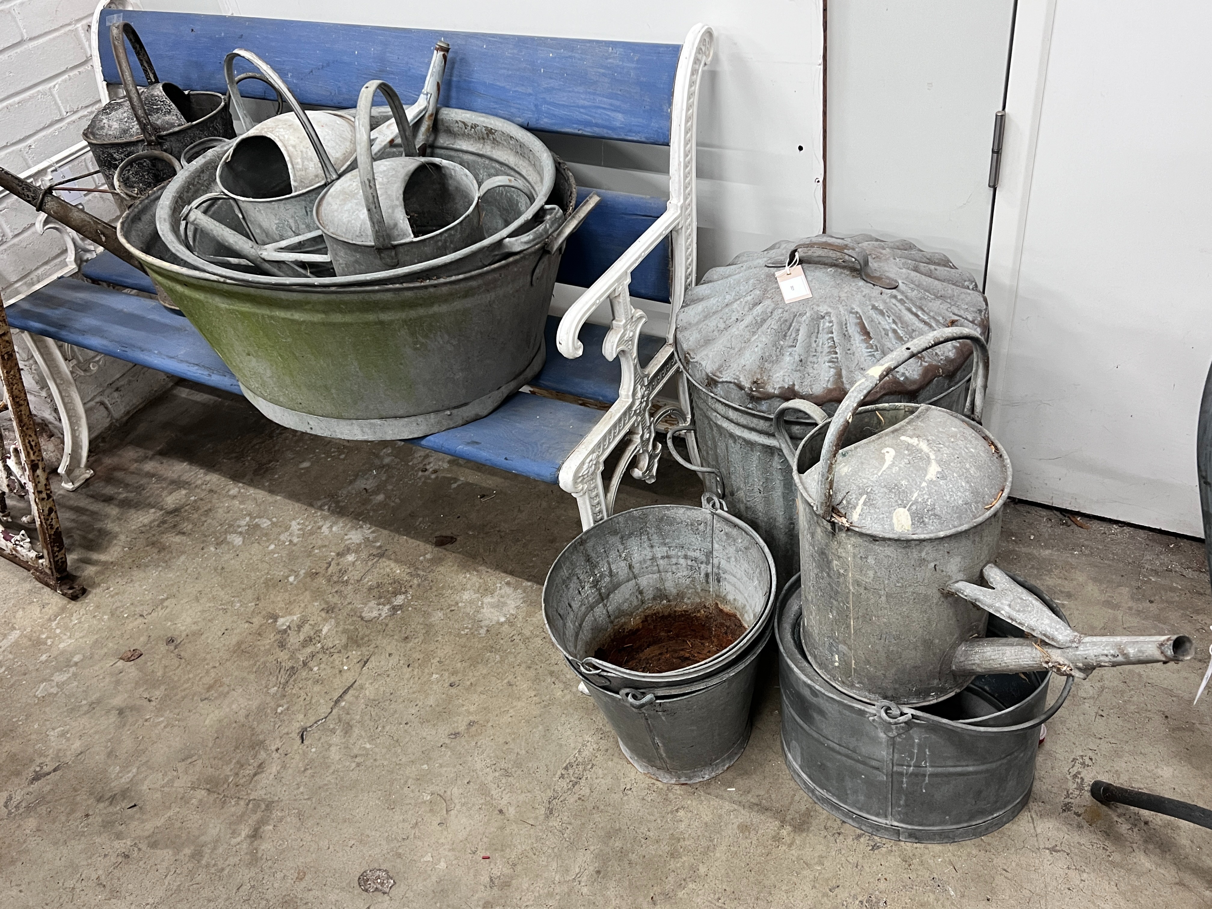 Ten assorted galvanised watering cans and containers, largest width 86cm